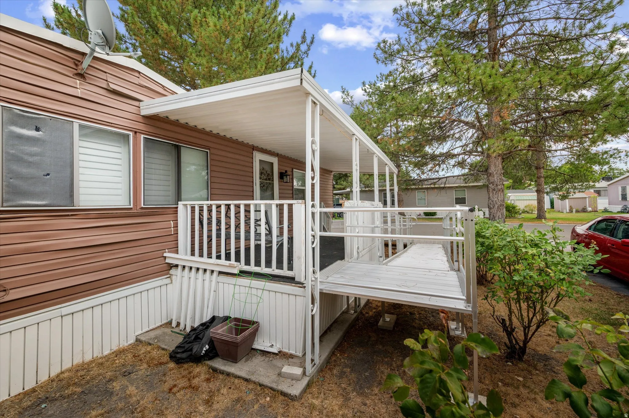 Covered porch with a white railing and a ramp entry