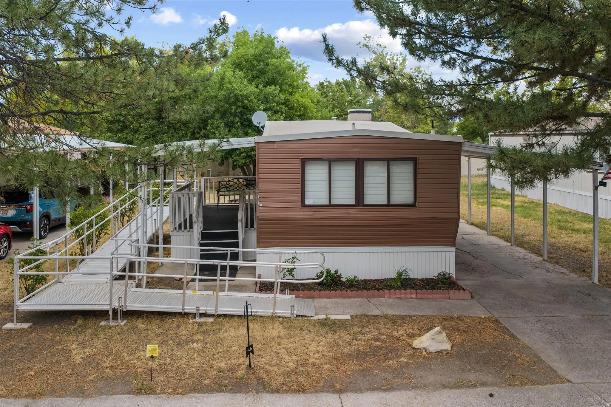 Brown horizontal siding with white trim and a covered carport