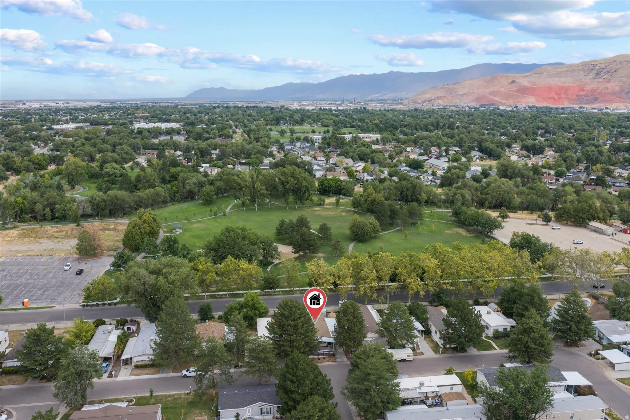 Aerial perspective featuring extensive green spaces, mature trees, and distant mountain ranges