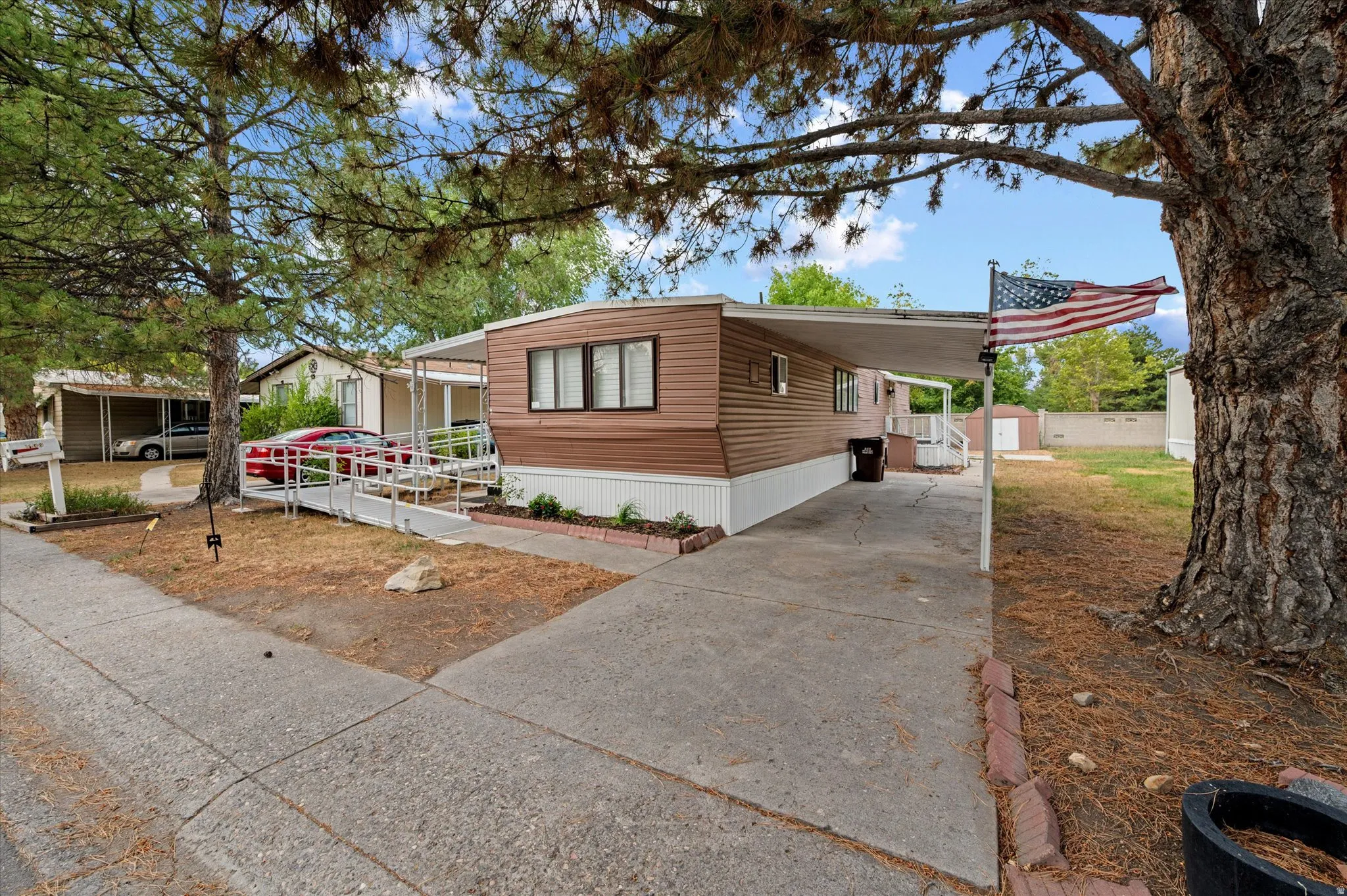Brown horizontal siding with white trim and a covered carport