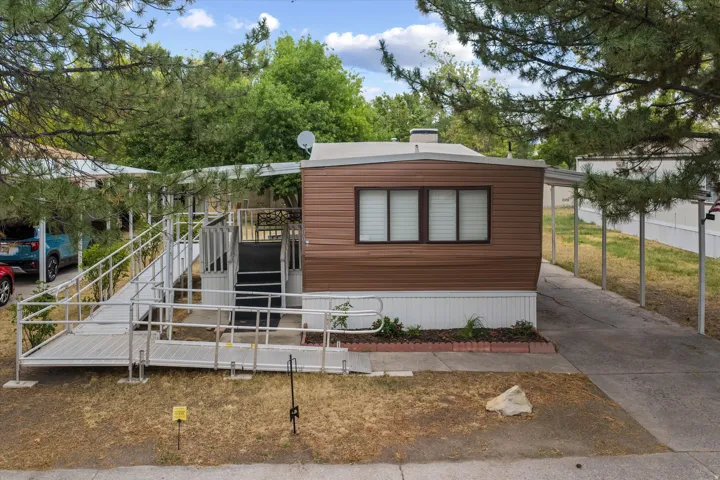 Brown horizontal siding with white trim and a covered carport