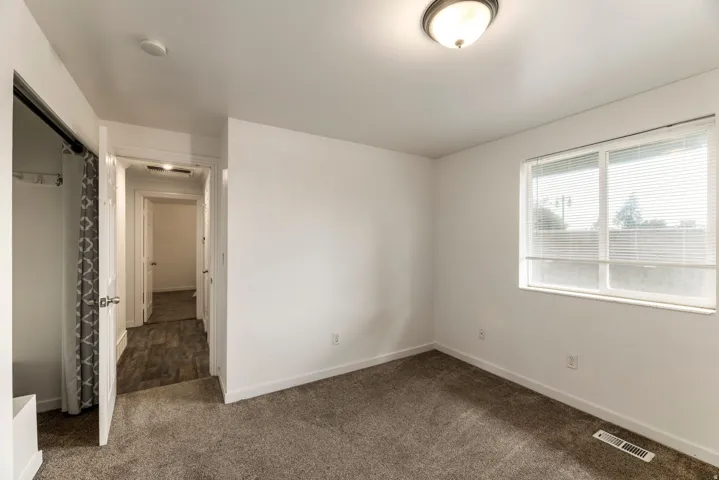 Bedroom featuring white walls, gray carpeting, a double window with blinds, and an overhead flush-mount light fixture