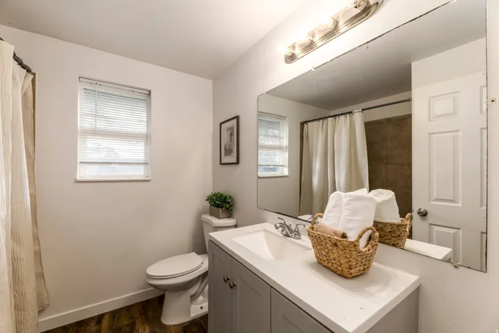 Bathroom featuring a large vanity with a white countertop and gray cabinetry