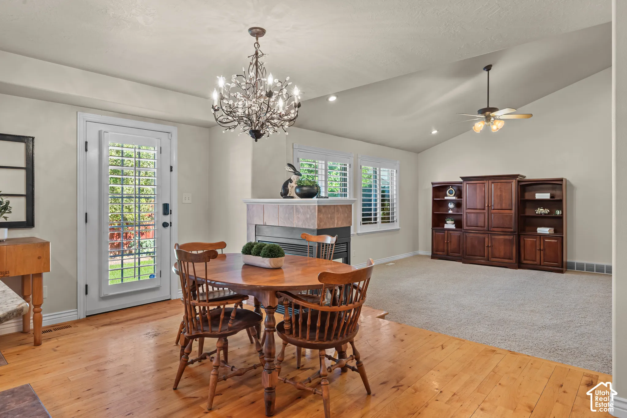 Open-concept living space featuring hardwood flooring, a contemporary chandelier, and French door to back patio