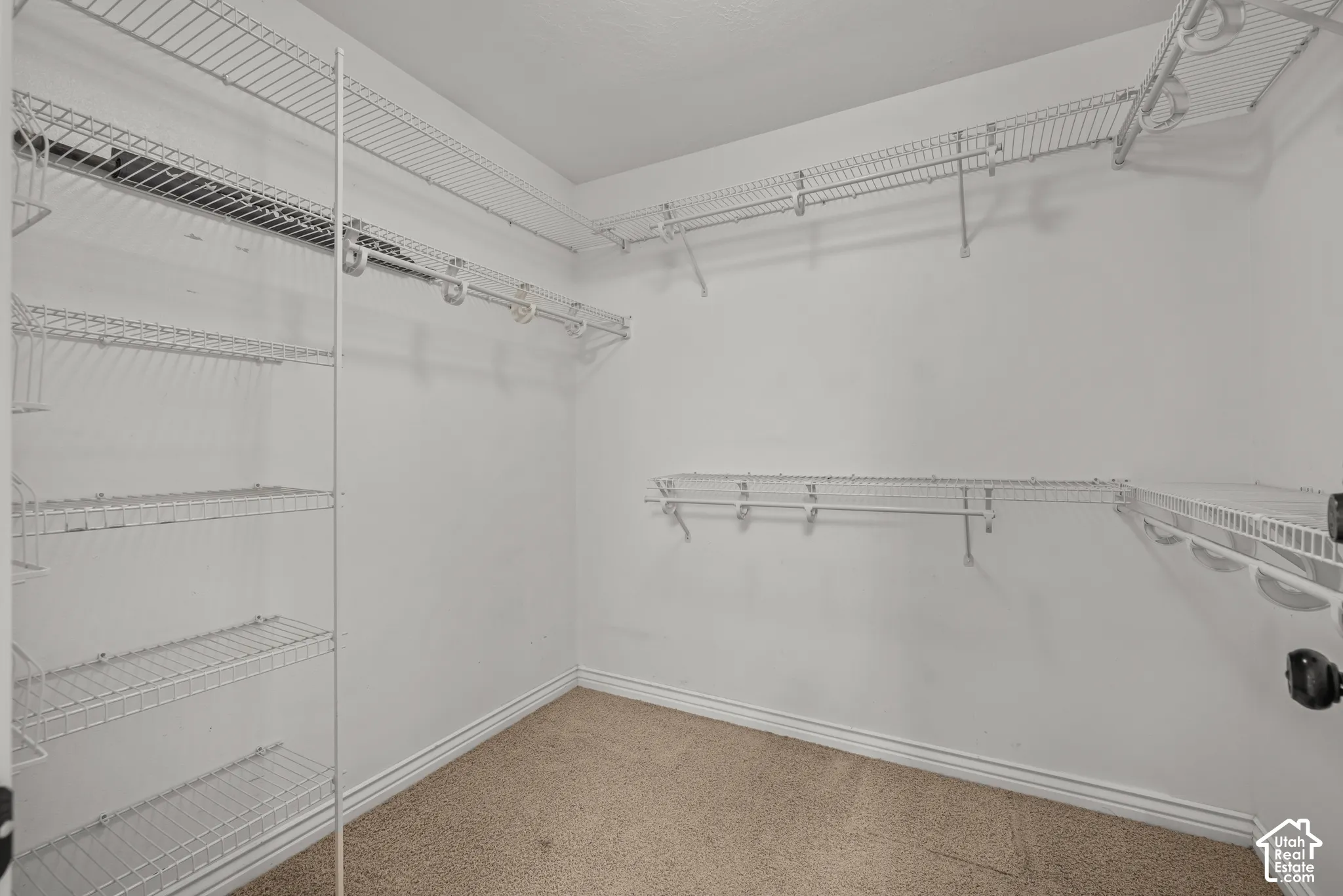 Primary Walk-in closet featuring white wire shelving, multiple hanging rods