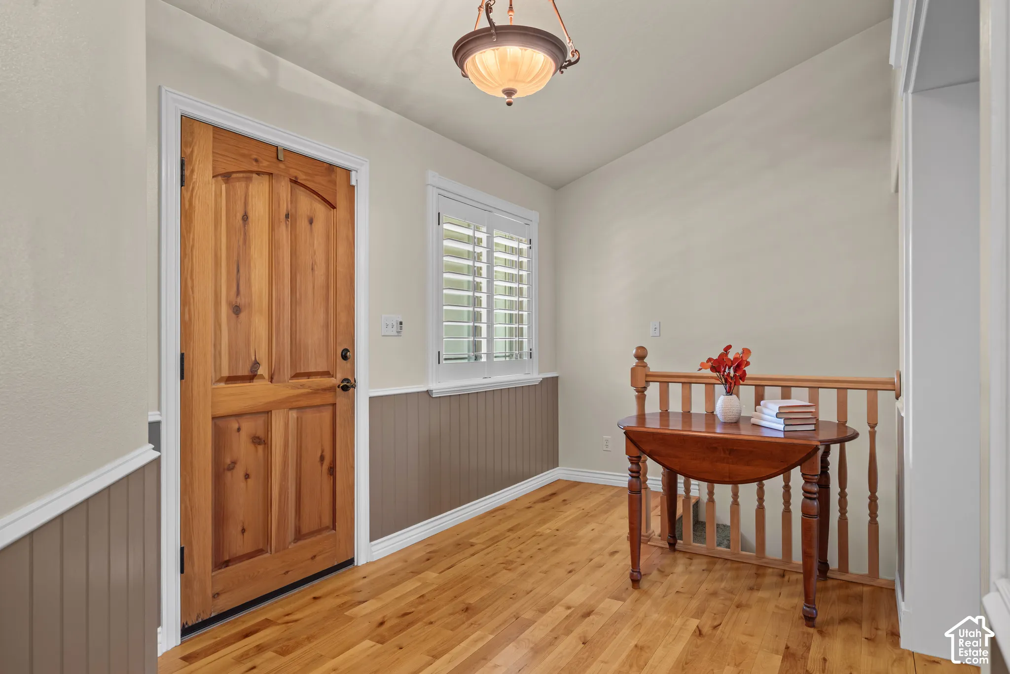 Hardwood flooring, contrasting wainscoting, solid wood door with panel detailing