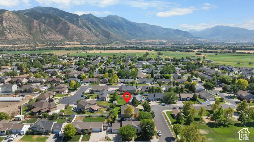 Suburban residential area with established homes, green spaces, and mountain backdrop