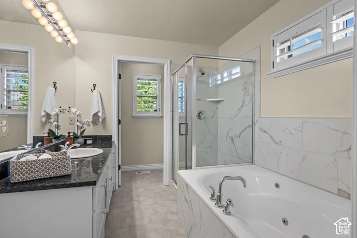 Primary bathroom with a jetted soaking tub, glass enclosed shower