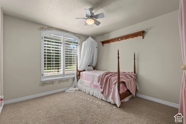 Bedroom 1 with plantation shutters and a ceiling fan