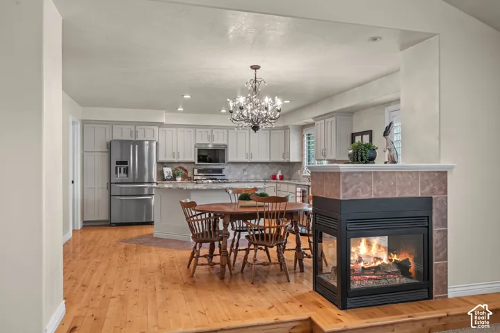 Open-concept dining area off kitchen with 2-way gas fireplace