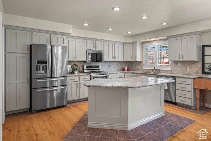 Kitchen with kitchen island and stainless steel appliances and recessed lighting