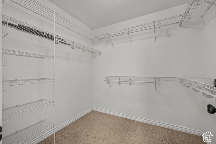 Primary Walk-in closet featuring white wire shelving, multiple hanging rods