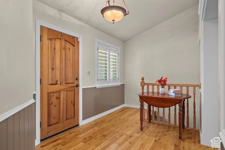 Hardwood flooring, contrasting wainscoting, solid wood door with panel detailing