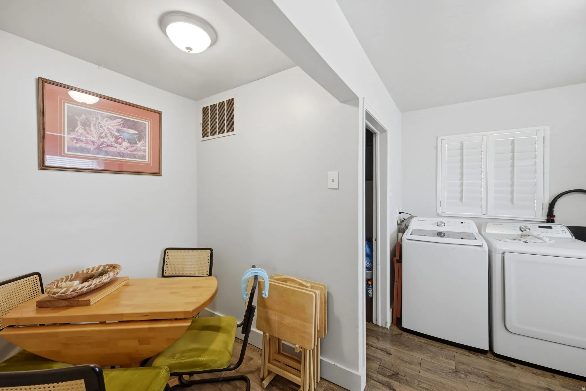 Wood-finish flooring with white walls and a ceiling light fixture