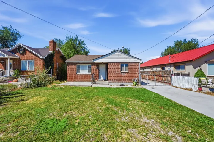 Brick exterior with white siding accents and a concrete driveway