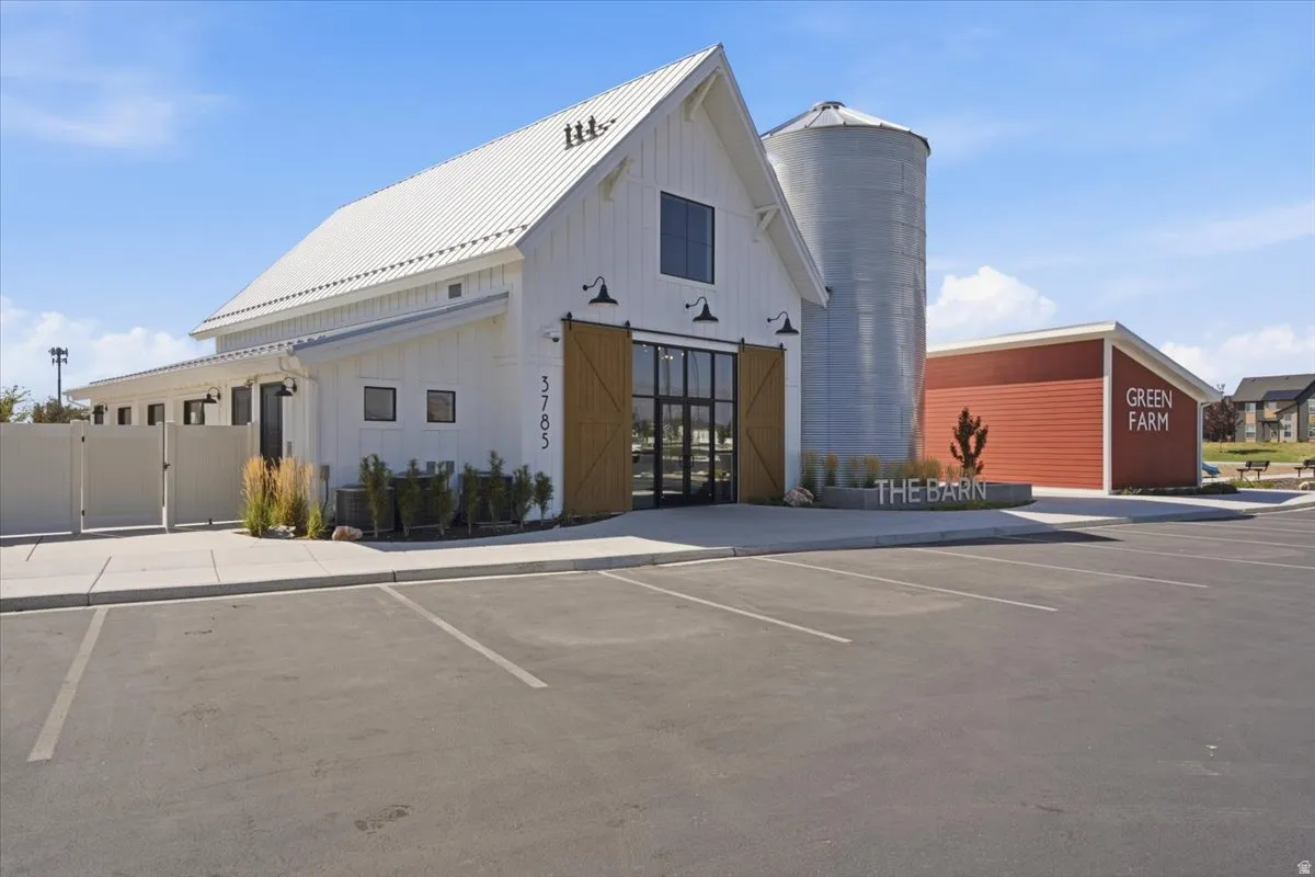Barn-style architectural structure featuring white vertical siding and a metal roof