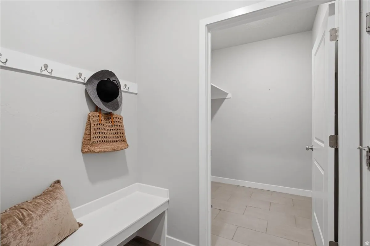 Entryway featuring a built-in bench, wall-mounted coat rack with hooks, and a neutral color palette