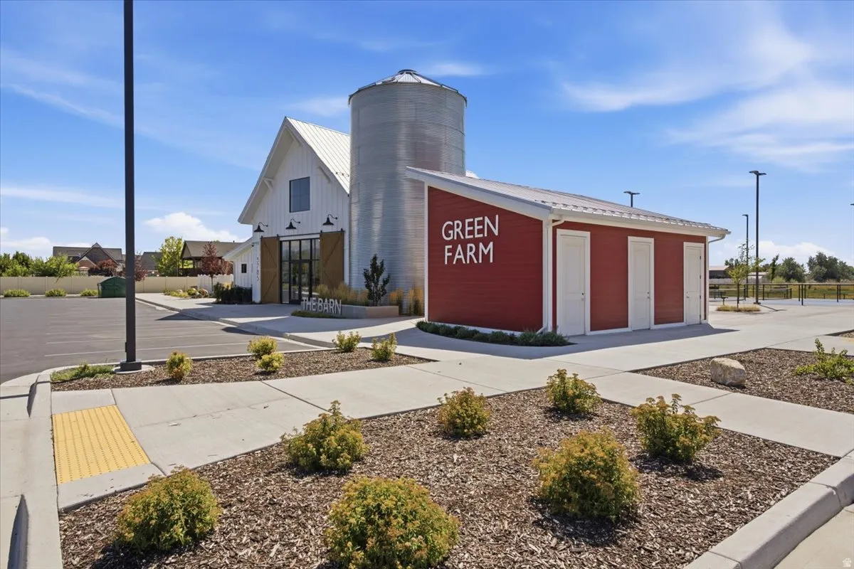Modern farmhouse-style building with white vertical siding and a prominent silo