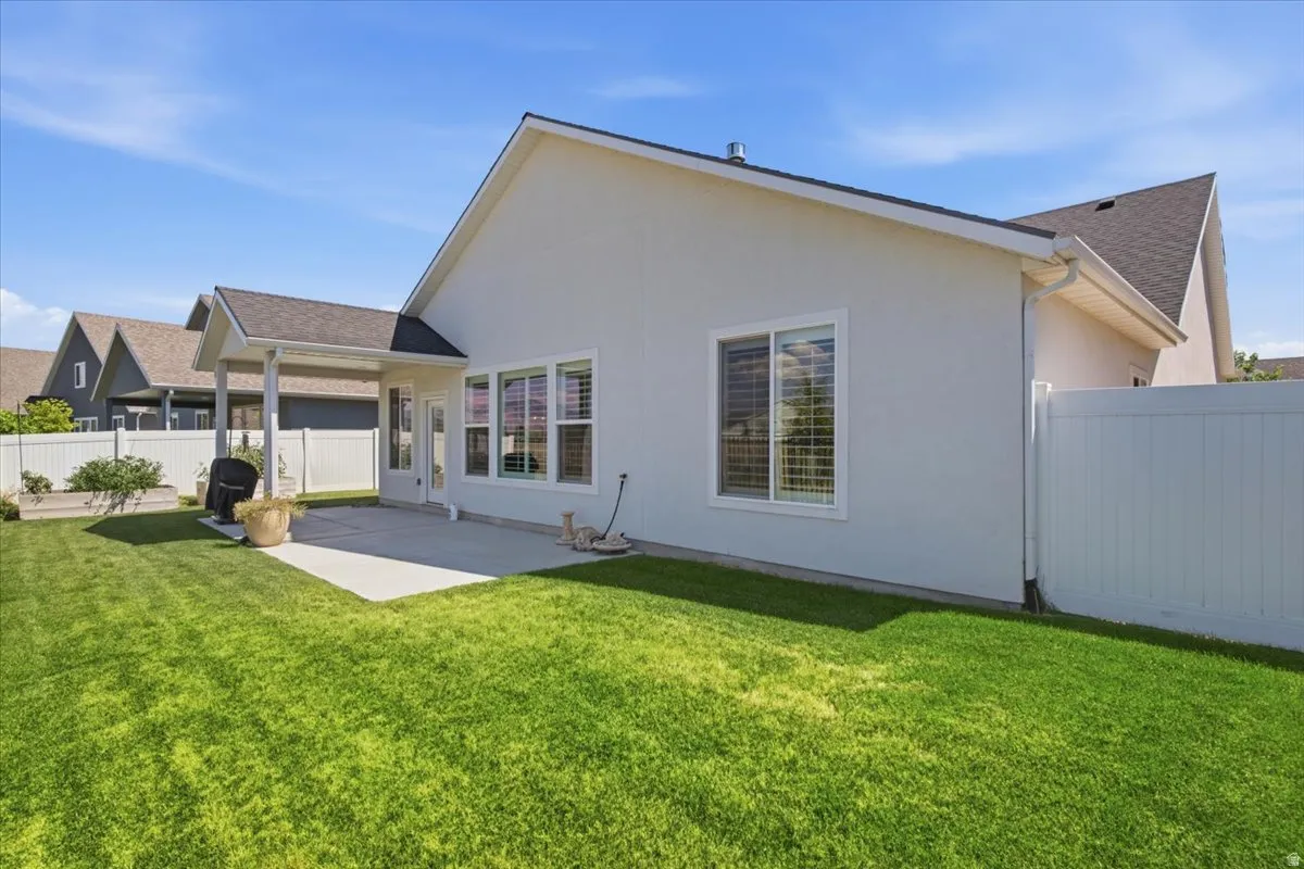Expansive green lawn with a white privacy fence