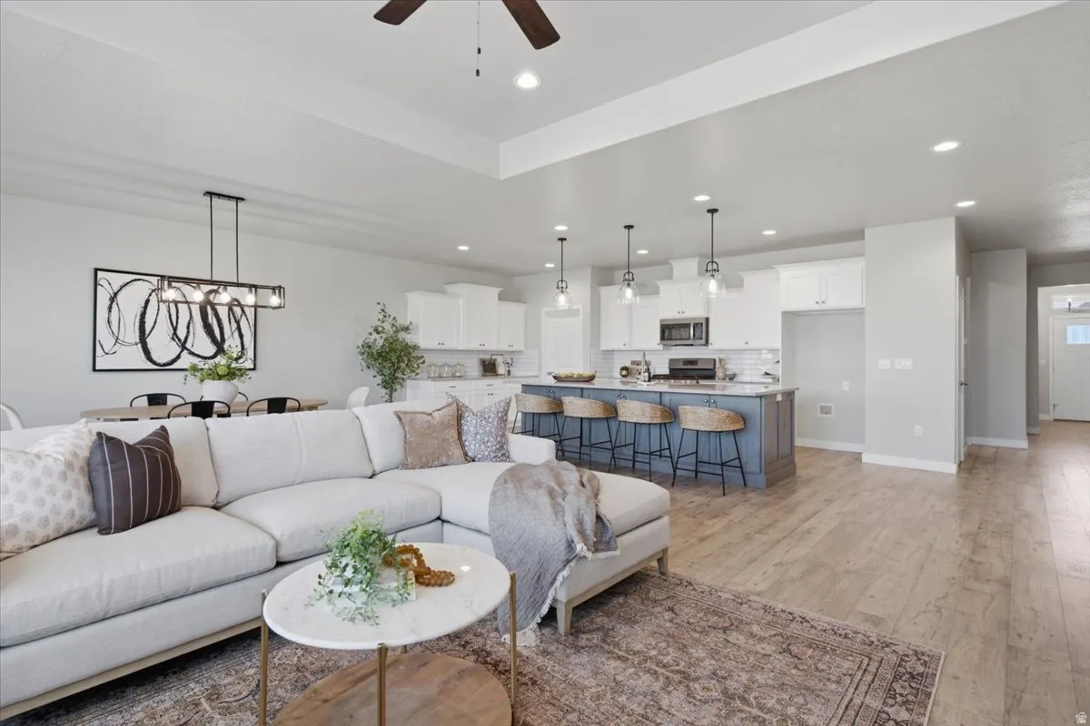 Open-concept living area featuring a vaulted ceiling and wood-finish flooring