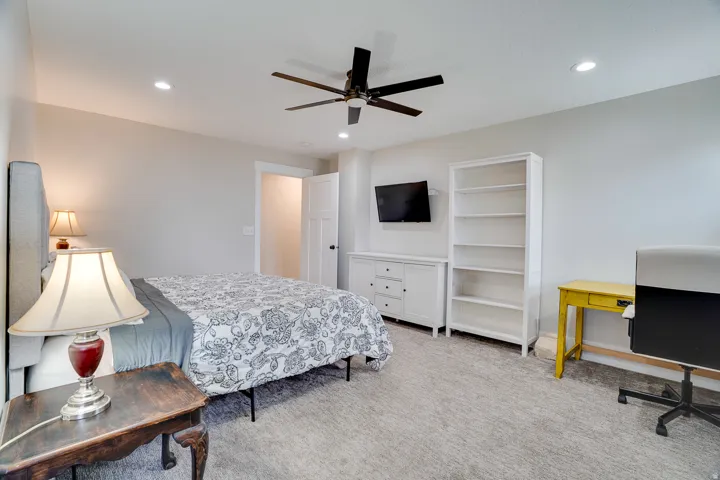 Carpeted bedroom featuring recessed lighting and a ceiling fan