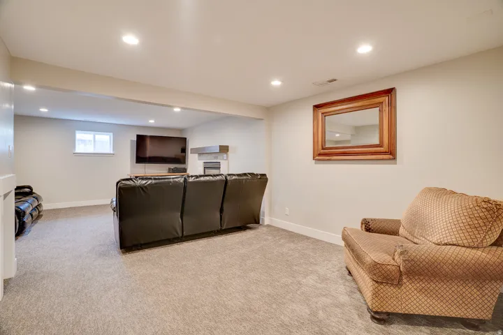 Lower-level recreation space featuring neutral wall paint and light-colored carpeting
