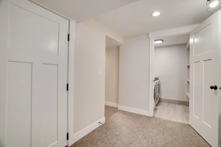 Dedicated laundry area with tile-finish flooring and integrated shelving