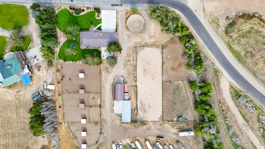 Expansive property featuring a main residence with a manicured lawn, multiple outbuildings, and an equestrian arena