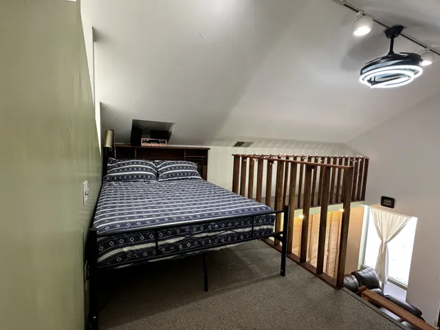 Bedroom 3 carpeted loft space featuring a sloping ceiling, track lighting, and a modern ceiling light