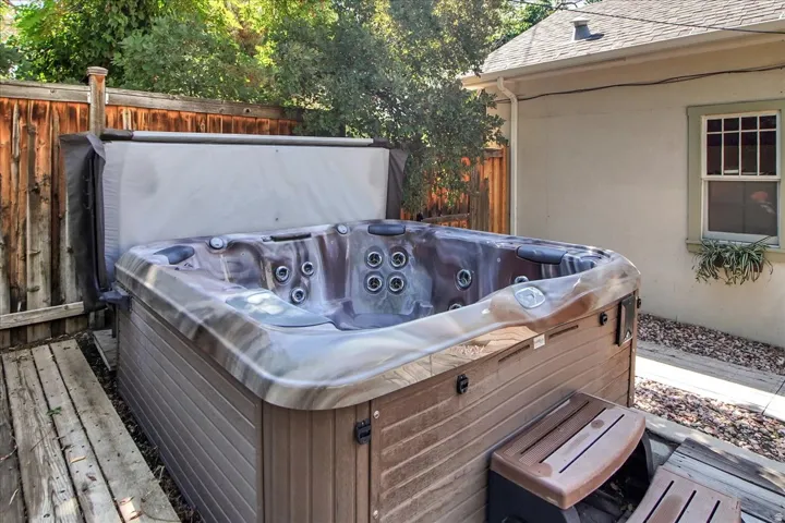 Outdoor spa on a wood deck, featuring a durable cover and integrated steps