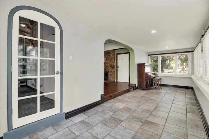 Sunroom with tile flooring and piano