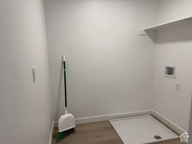 Laundry area featuring a built-in shelf, appliance hookups, and wood-finish flooring