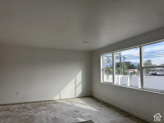 Spacious room featuring multiple large windows and recessed lighting