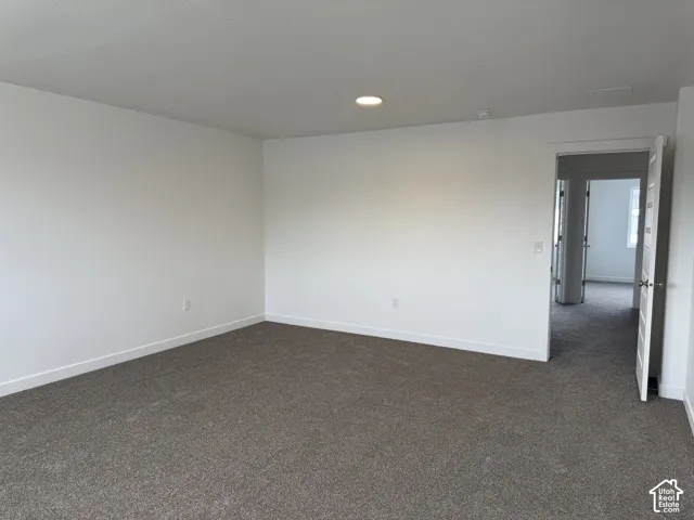 Carpeted room with white walls, recessed lighting, and white trim