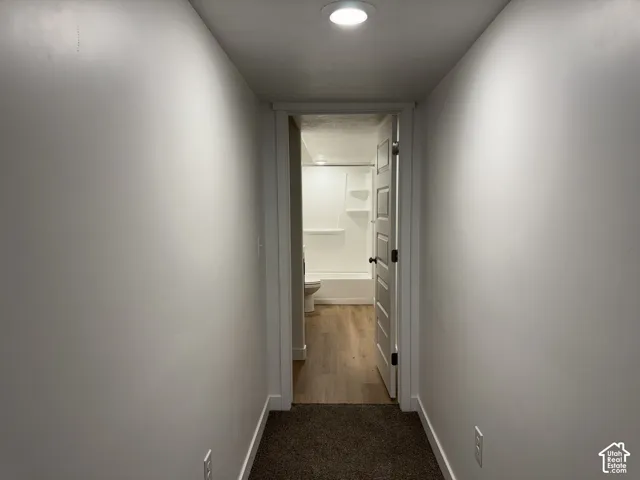 Neutral wall tones, recessed lighting, wood-finish flooring, and a multi-panel interior door