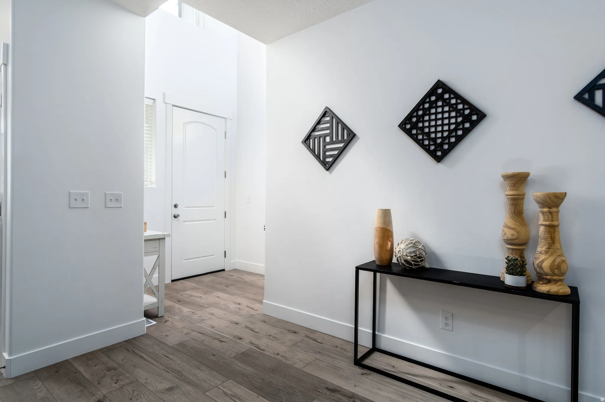 Entryway featuring wood-finish flooring, crisp white walls, and a recessed window