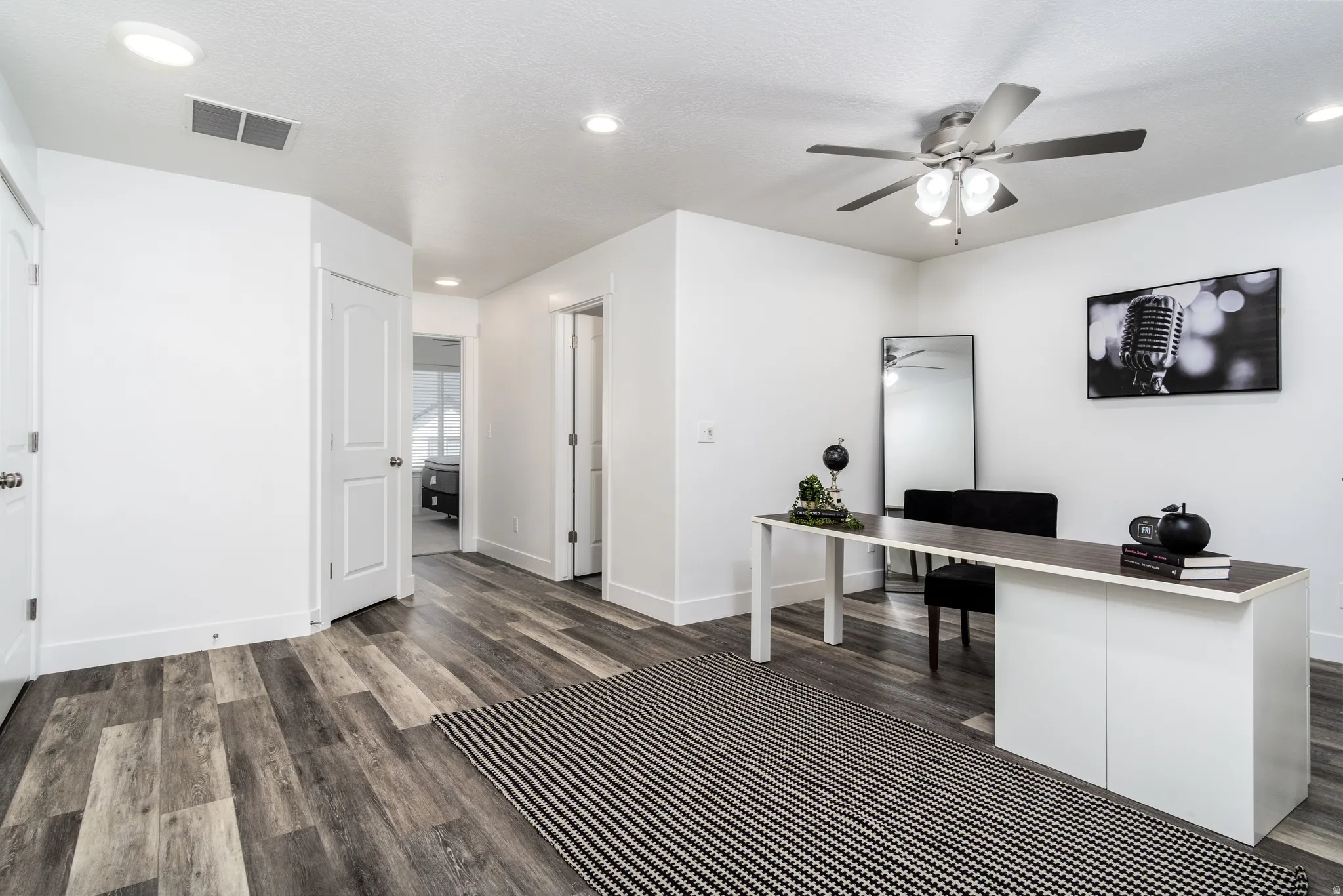 Open room featuring wood-finish flooring, recessed lighting, and a ceiling fan with integrated lighting