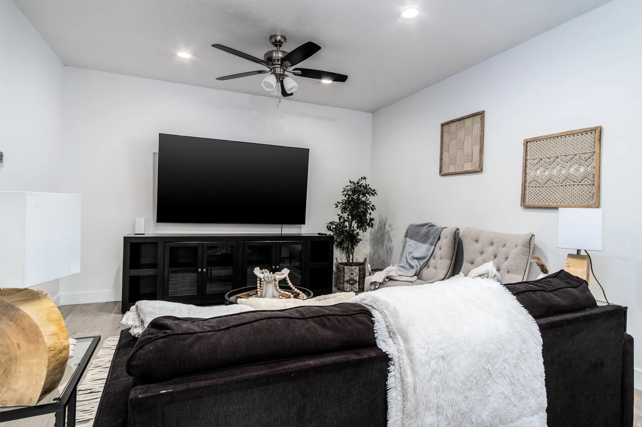 Living area featuring light wood-finish flooring, recessed ceiling lighting, and a ceiling fan with light fixture