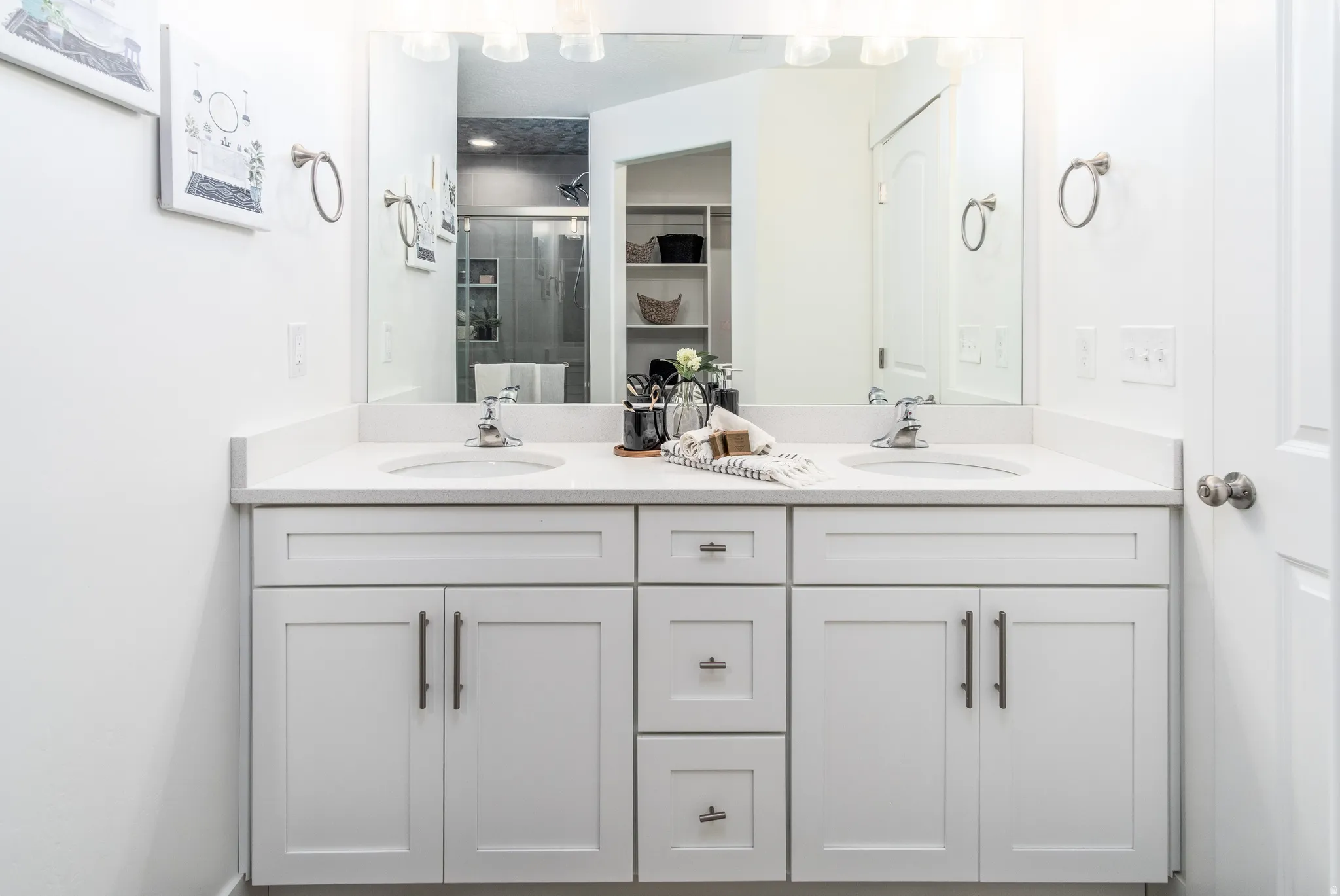 Dual vanity with white cabinetry, brushed nickel hardware, and a light-toned countertop