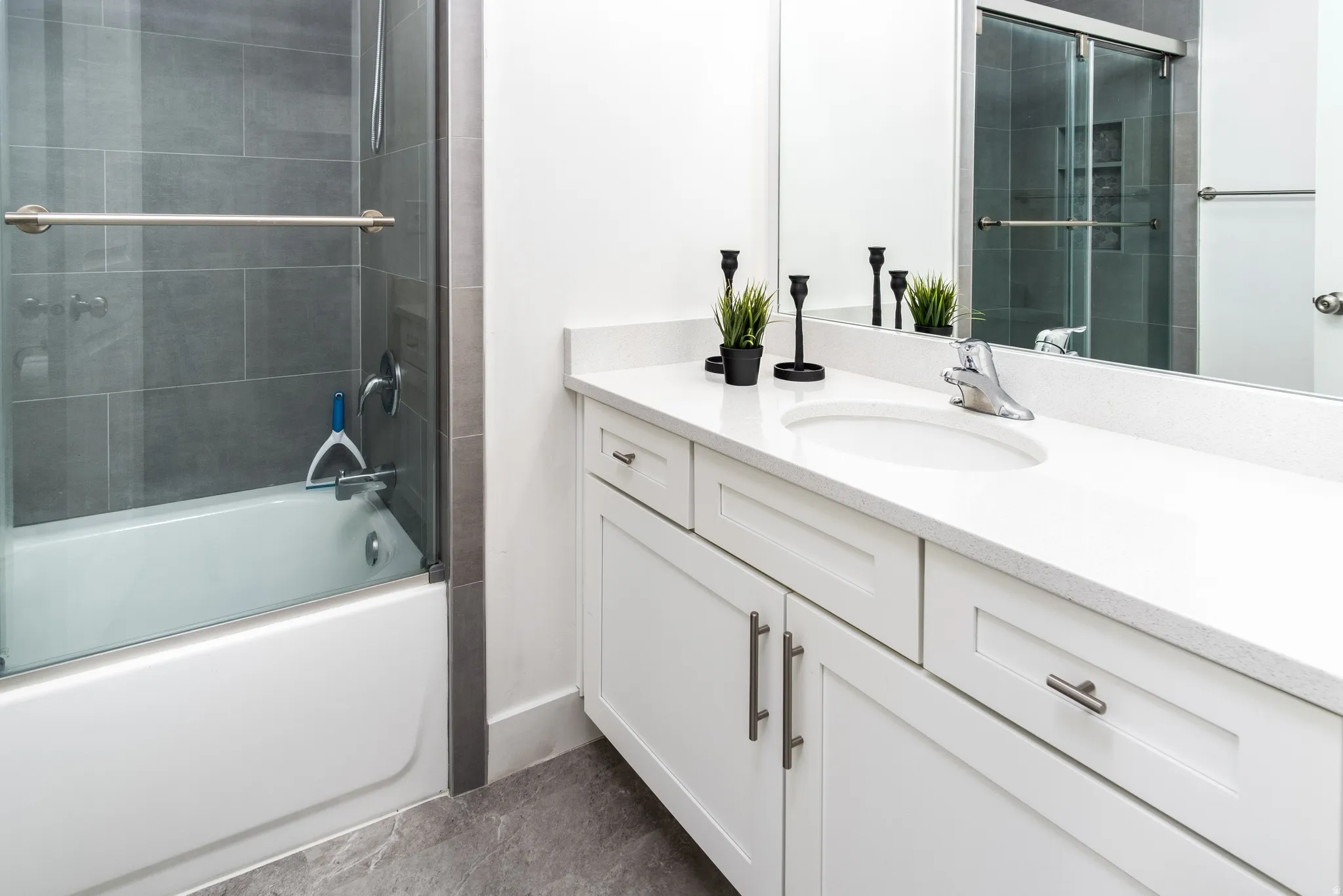 White vanity with an integrated sink and light-toned countertop, featuring chrome hardware