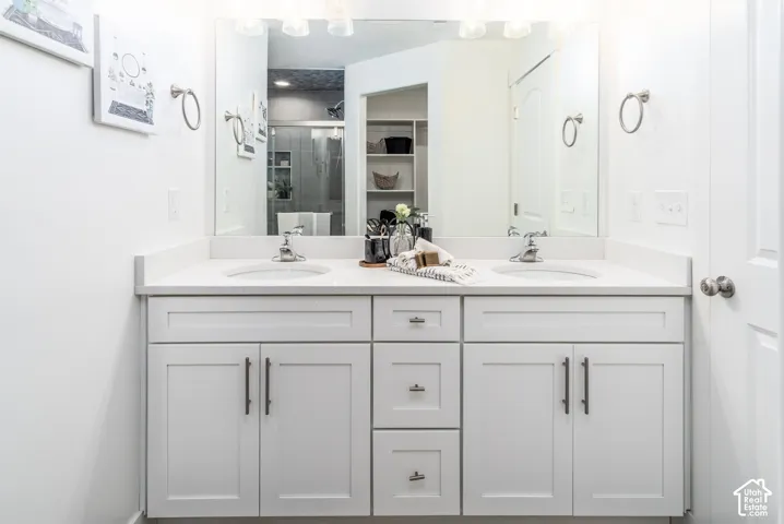 Dual vanity with white cabinetry, brushed nickel hardware, and a light-toned countertop