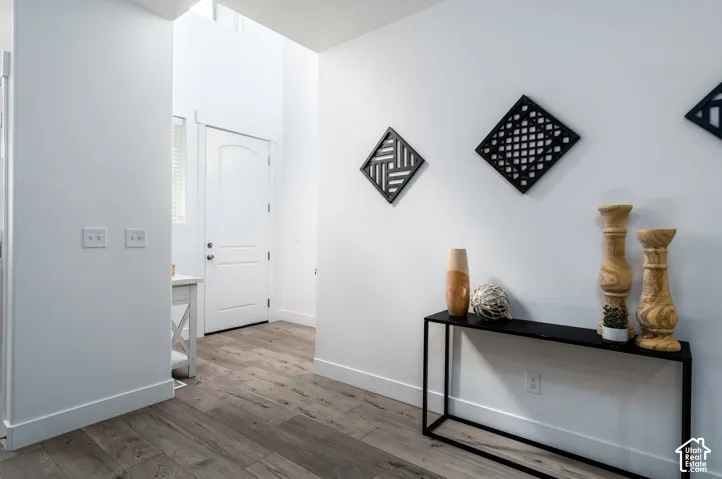 Entryway featuring wood-finish flooring, crisp white walls, and a recessed window