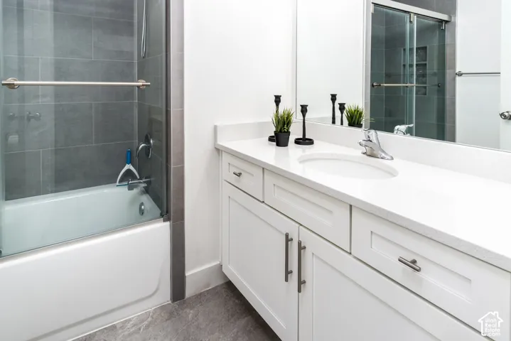 White vanity with an integrated sink and light-toned countertop, featuring chrome hardware
