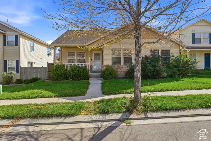 Light yellow siding exterior with a covered front porch featuring white railings