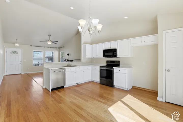 Kitchen featuring white cabinetry, black appliances, a stainless steel dishwasher, and a light-toned wood-finish floor