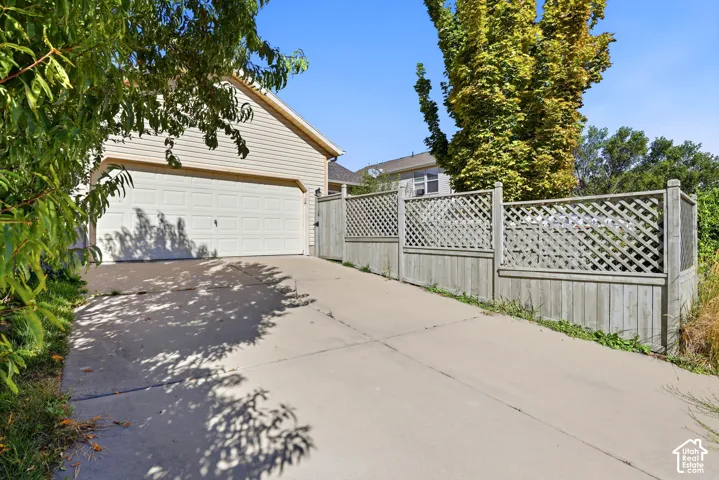 Attached two-car garage with a concrete driveway and wood-finish siding