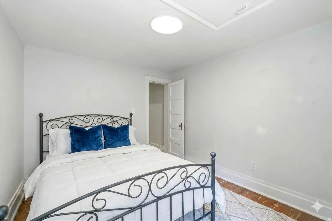 Bedroom featuring light wall paint, a ceiling-mounted light fixture, and wood-finish flooring