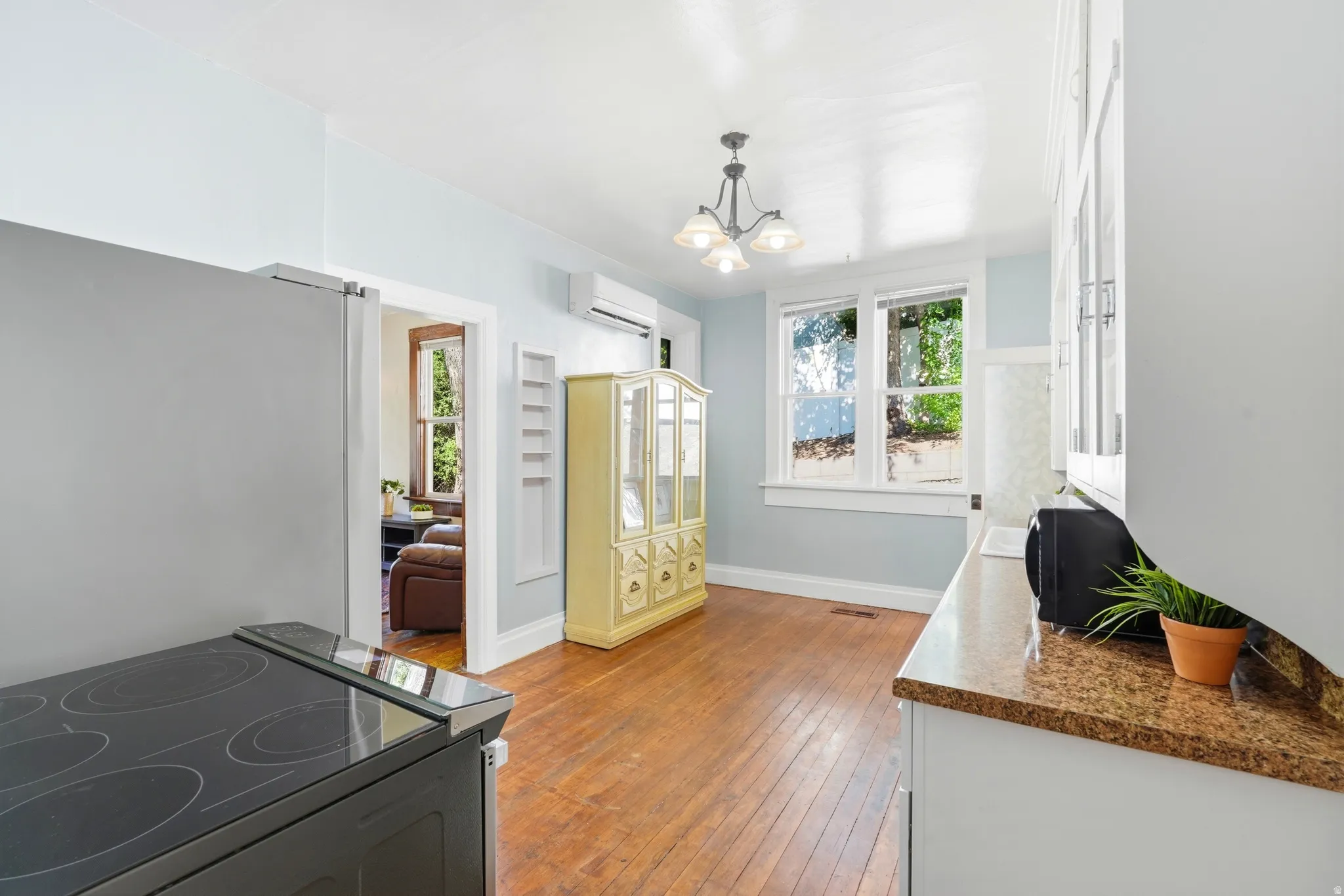 Kitchen featuring wood-finish flooring, light blue walls, and a multi-pane window