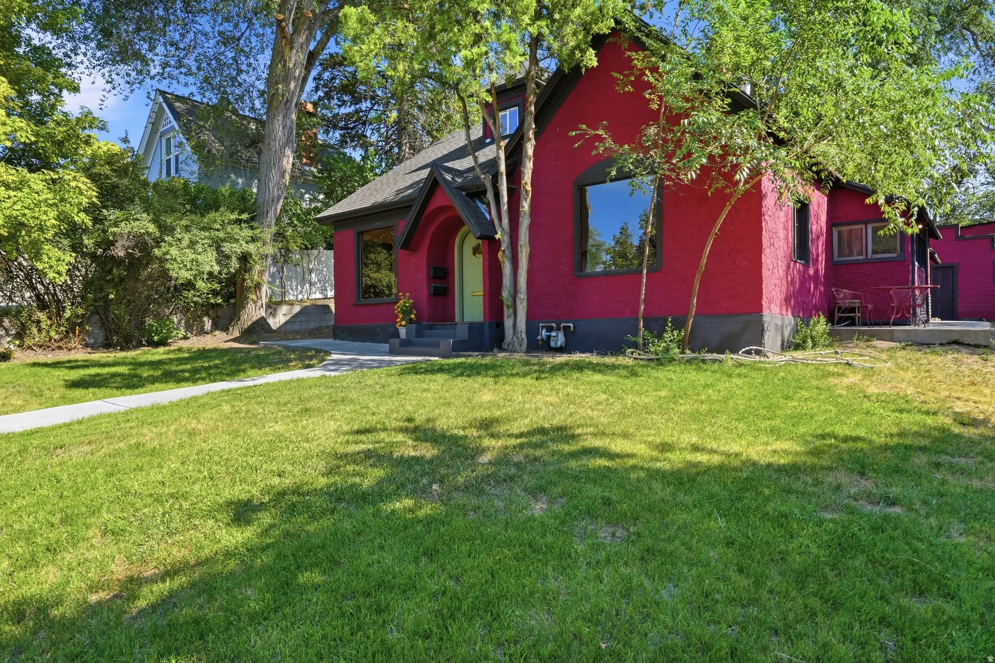 Crimson stucco exterior with a contrasting dark trim and a bright green front door