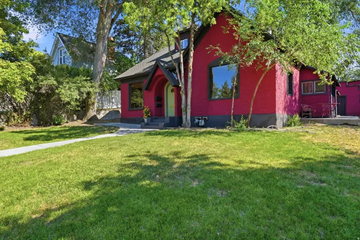 Crimson stucco exterior with a contrasting dark trim and a bright green front door